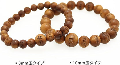 一條由日本百年老店滝田商店製作、散發極致玄學正氣的尊貴屋久杉木玉手鍊。手鍊由直徑約 8mm 的稀缺天然屋久杉木珠串成，每顆木珠上都以匠心工藝精細雕刻著微型的「光明真言」梵字。中央直徑約 11mm 的親珠則單獨雕刻著代表大日如來的梵字「阿字」，木頭表面帶有天然溫潤的黃褐色木紋，整體散發出高僧加持般的強大辟邪與木行能量質感。